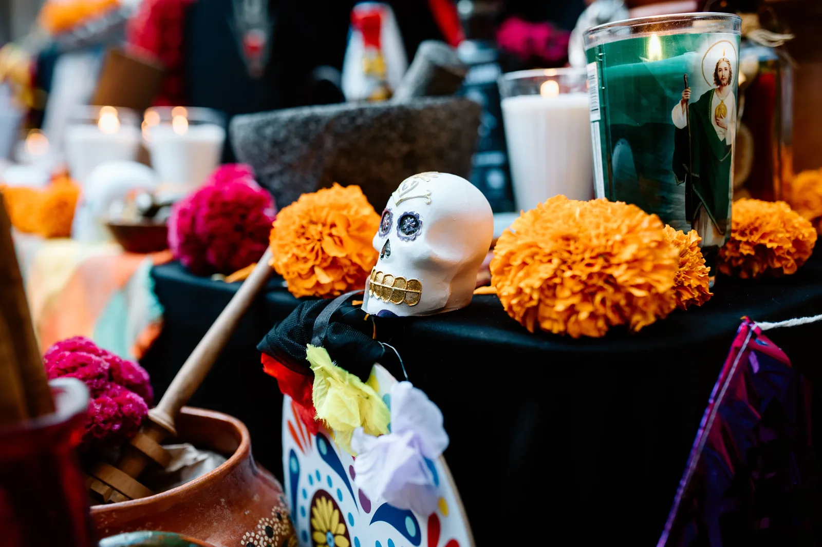 Altar do Dia de Muertos com caveira decorada, flores de cempasúchil e velas acesas