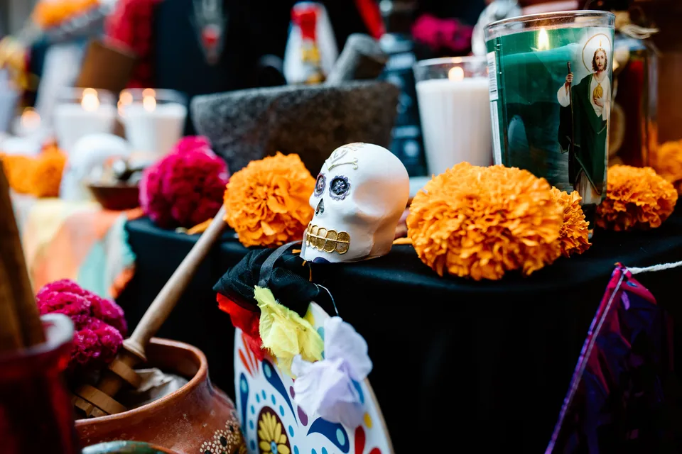 Altar do Dia de Muertos com caveira decorada, flores de cempasúchil e velas acesas