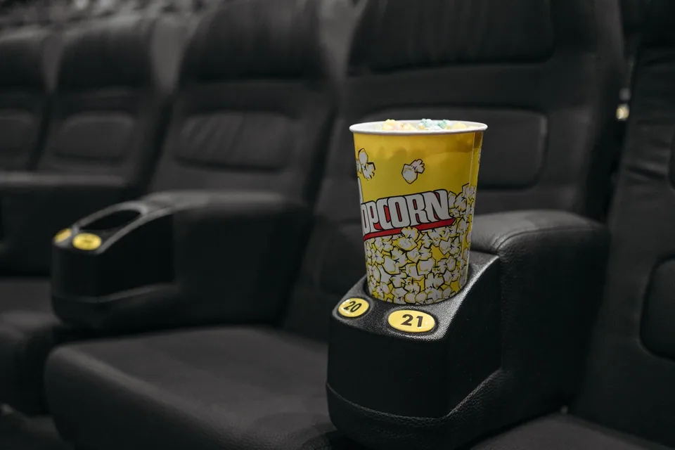 Balde de pipoca no porta-copos de uma poltrona de cinema