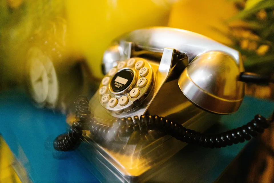 Telefone retrô prateado com disco de discar, em foto ilustrativa
