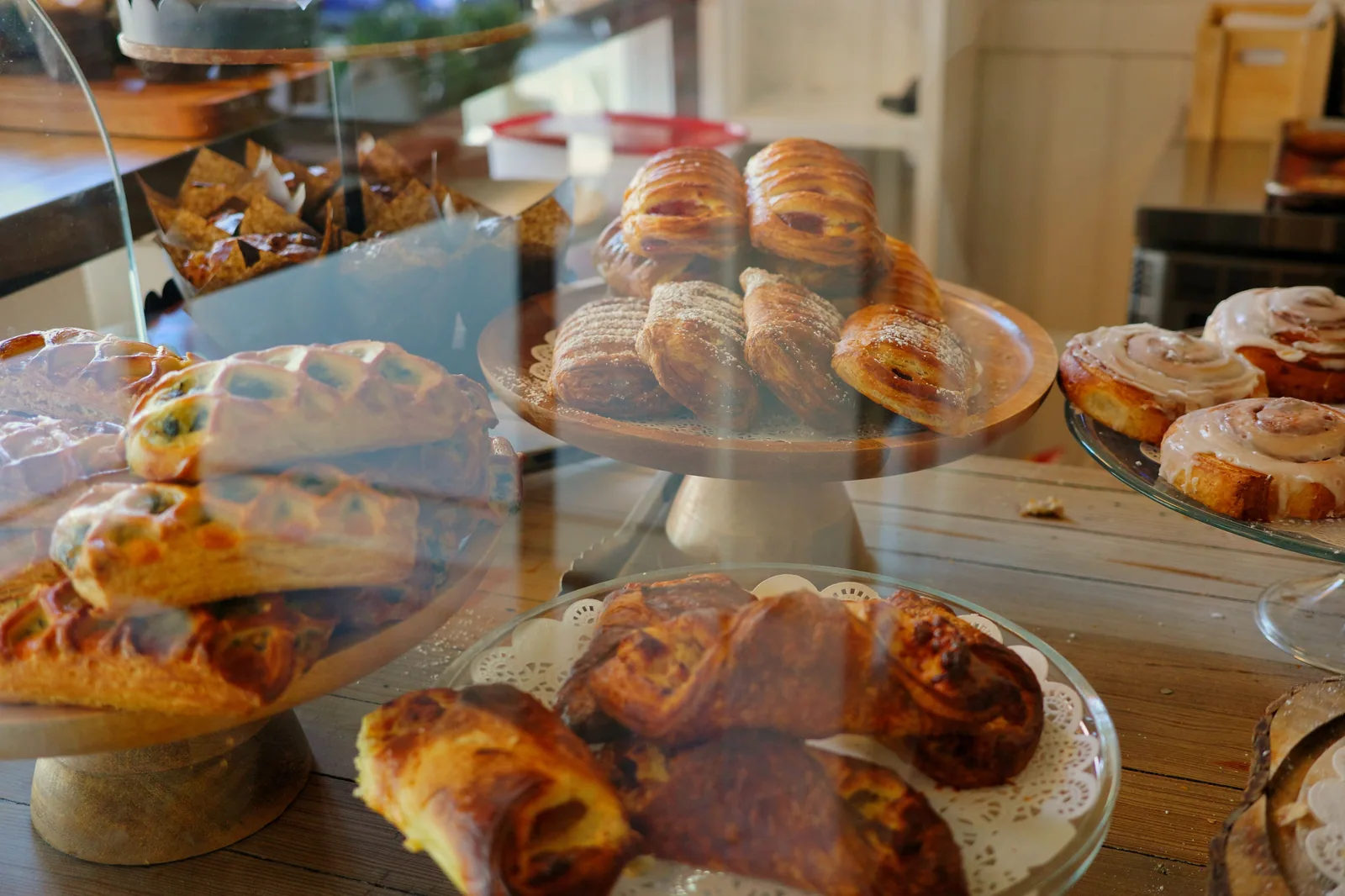 Vitrine de padaria com croissants, folhados e brioches em bandejas de vidro