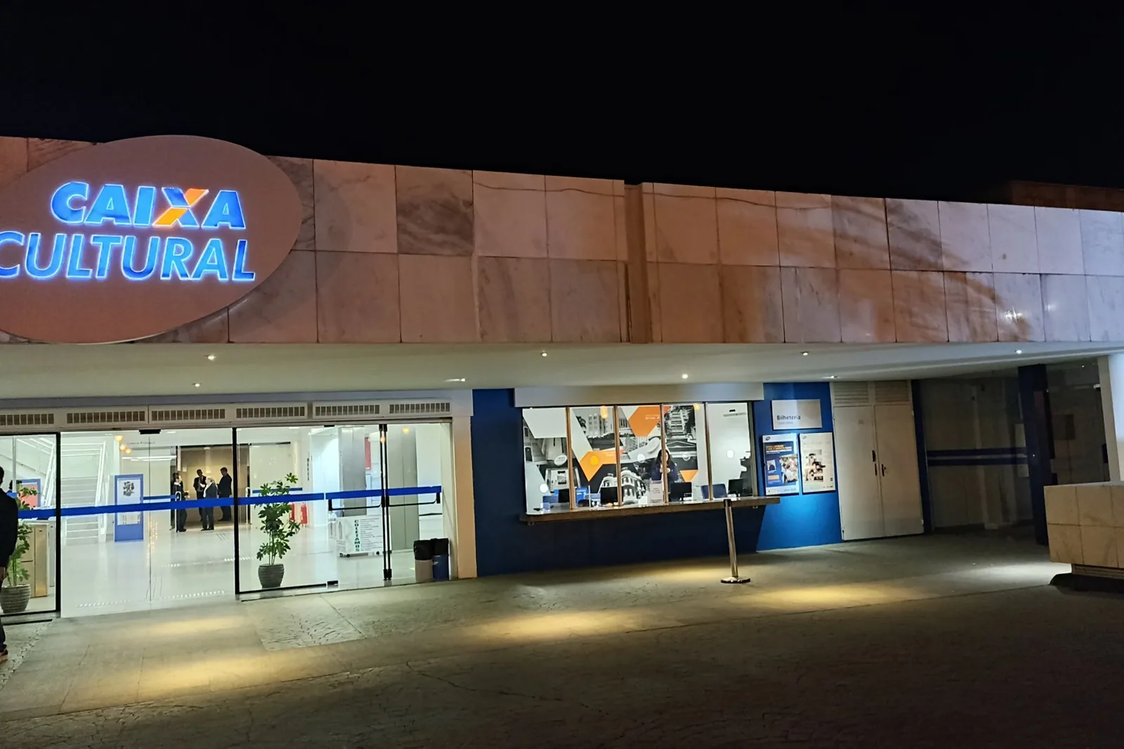 Fachada da Caixa Cultural Brasília, no Setor Bancário Sul, vista à noite com o letreiro iluminado e a bilheteria