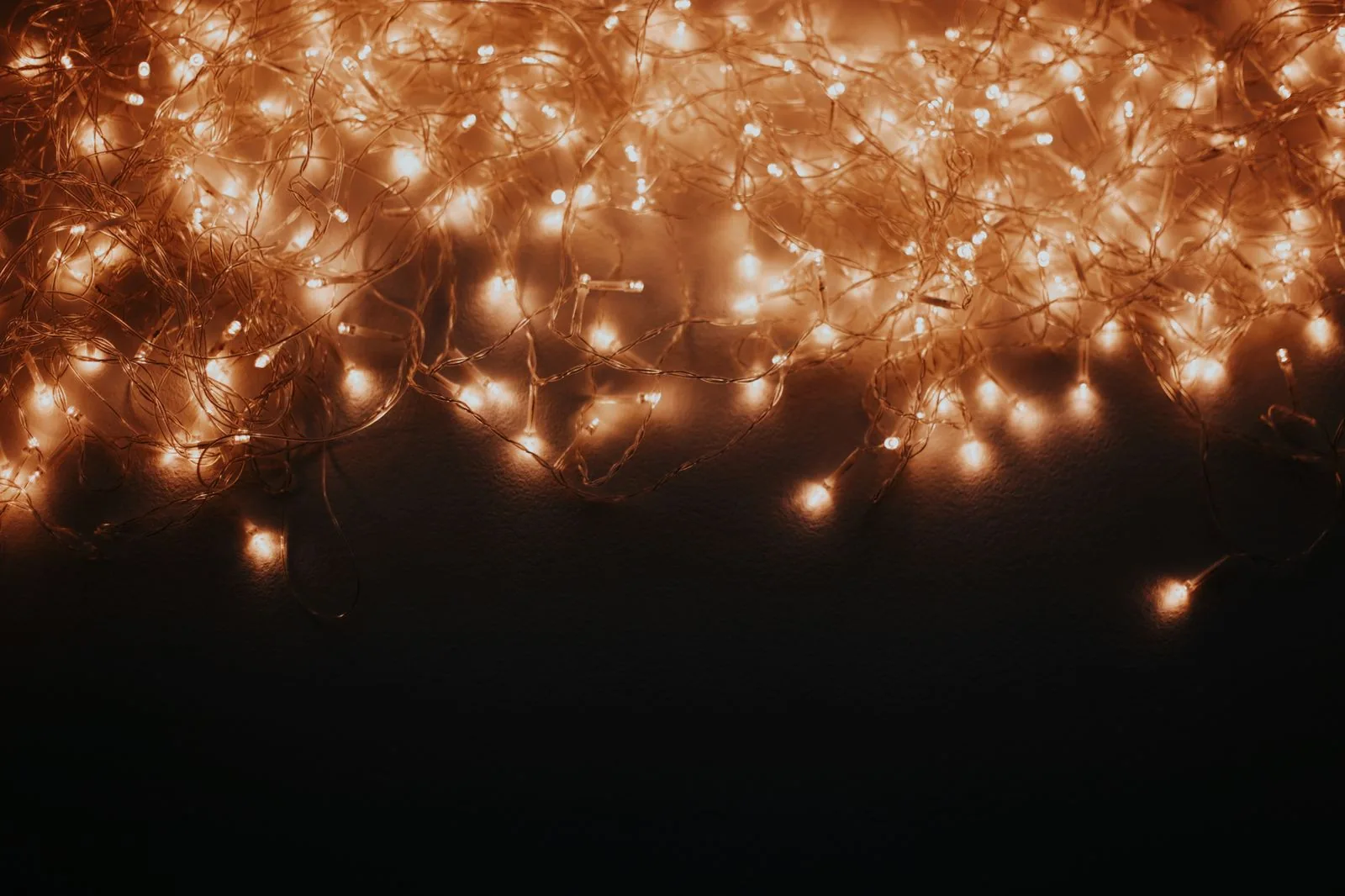 Luzes de Natal acesas sobre fundo escuro, em foto ilustrativa