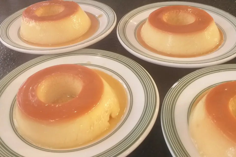 Pudins de leite condensado com calda de caramelo em pratos individuais; foto de arquivo, não é do Caseratto