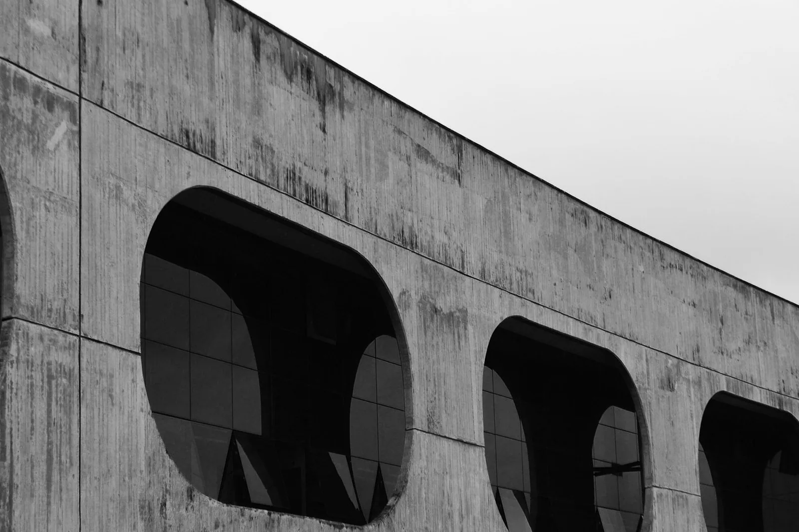 Fachada de concreto do CCBB Brasília com janelas de cantos arredondados, em foto preto e branco