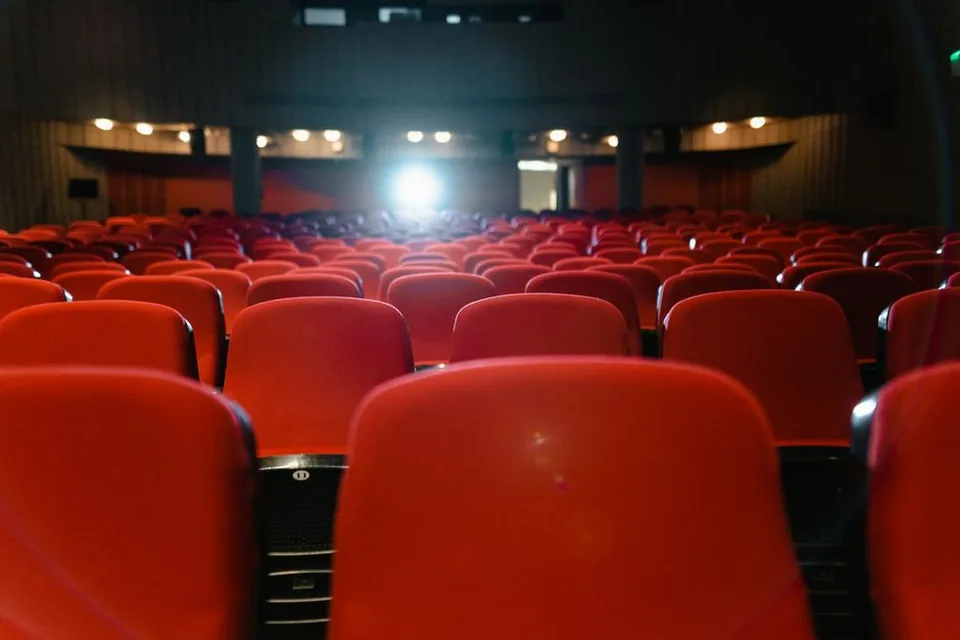 Sala de cinema vazia com poltronas vermelhas