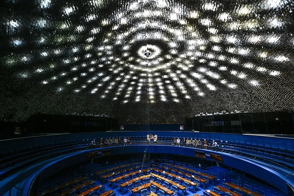 Plenário do Senado Federal visto de cima, com visitantes sentados na galeria e o teto de alumínio do Palácio do Congresso