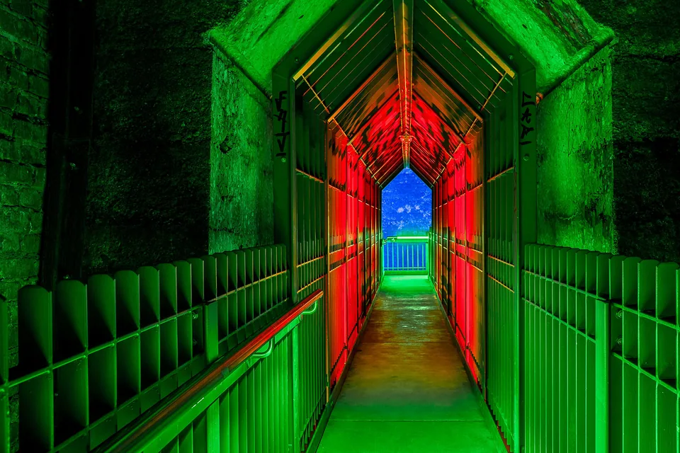 Corredor industrial iluminado por luzes verdes e vermelhas, imagem ilustrativa