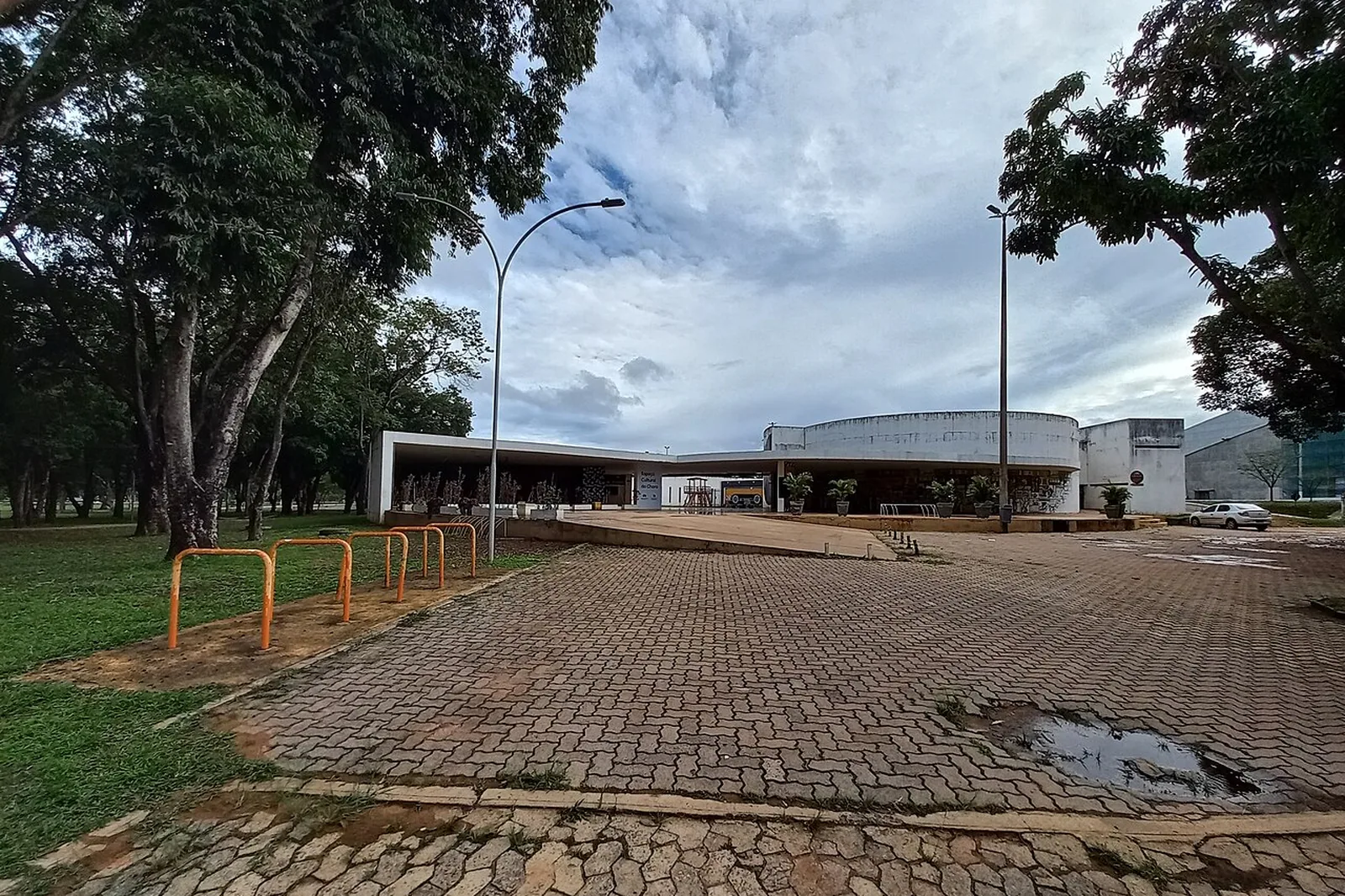 Fachada do Clube do Choro de Brasília, no Setor de Divulgação Cultural, com árvores e calçada de pedra em primeiro plano