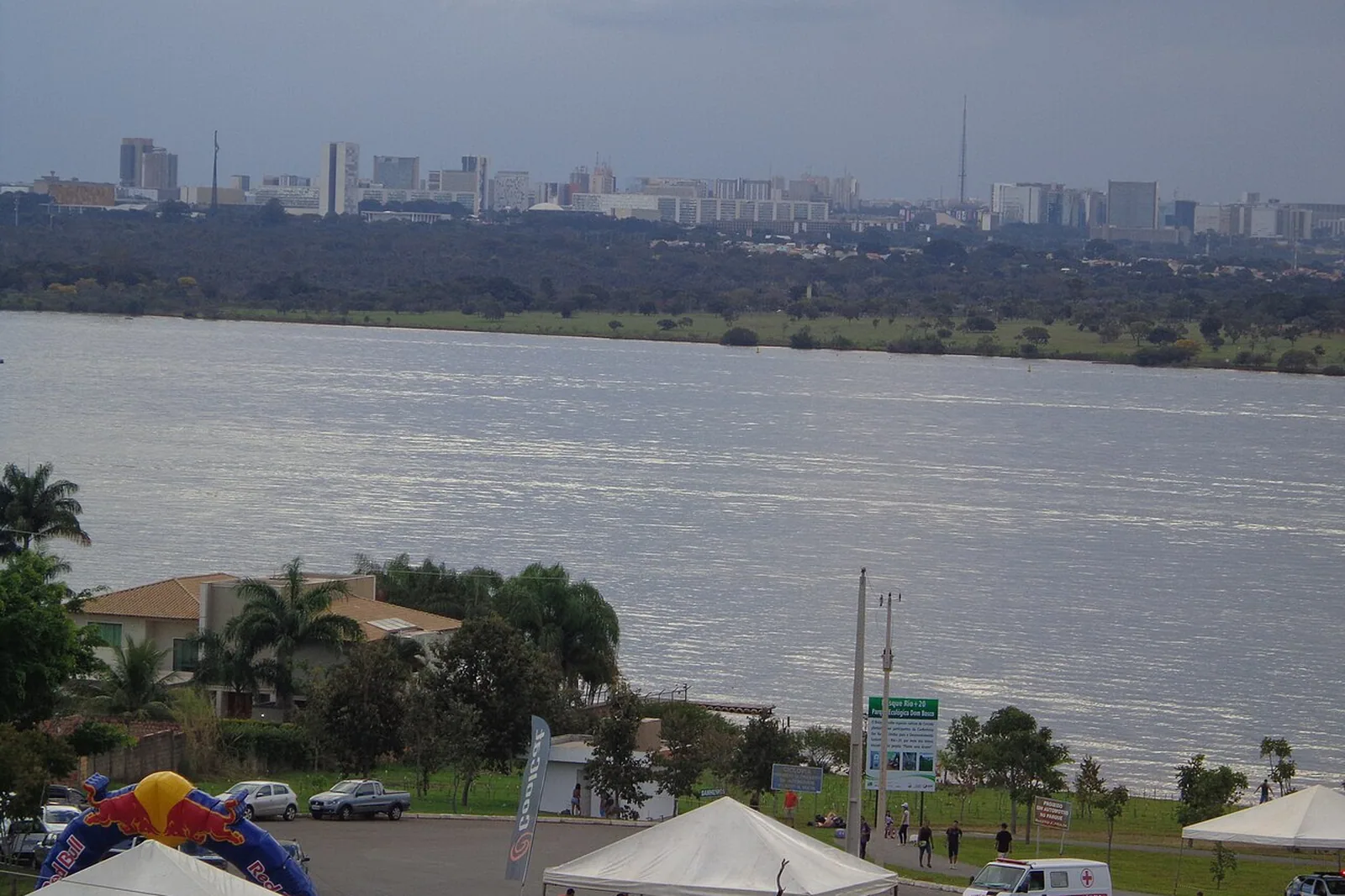 Vista do Parque Ecológico Dom Bosco para o Lago Paranoá, com o Plano Piloto e a Torre de TV ao fundo e barracas de evento no estacionamento. Foto de arquivo.
