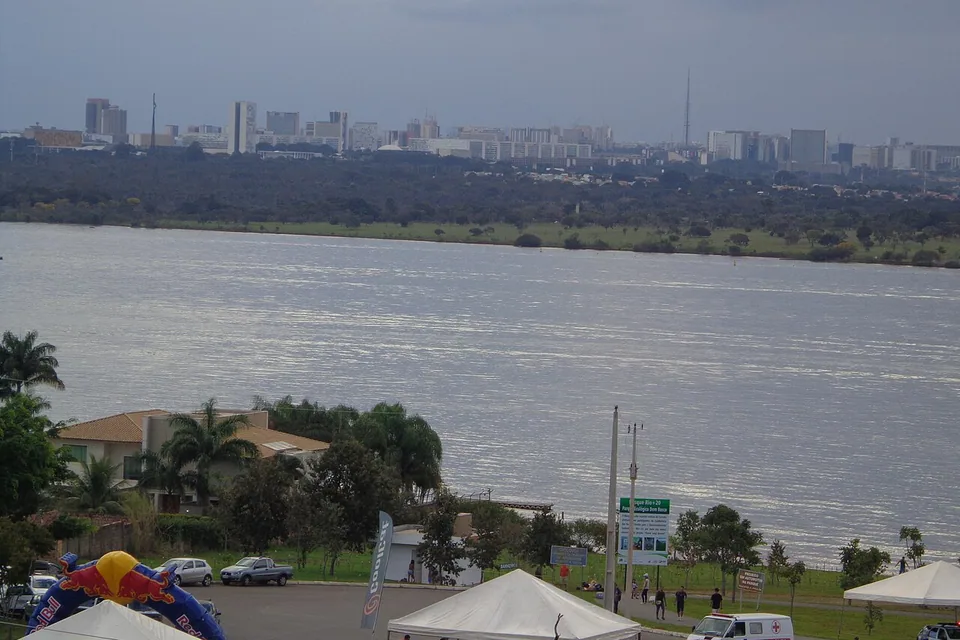 Vista do Parque Ecológico Dom Bosco para o Lago Paranoá, com o Plano Piloto e a Torre de TV ao fundo e barracas de evento no estacionamento. Foto de arquivo.