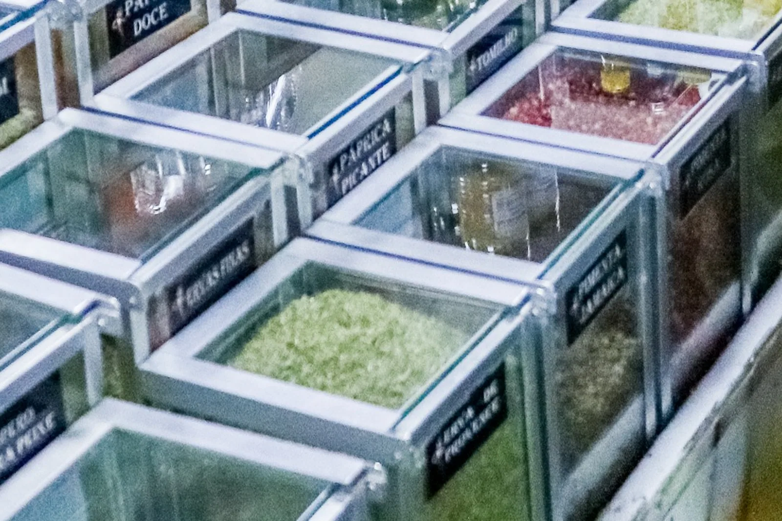 Caixas de vidro com temperos a granel em uma banca da Feira do Guará