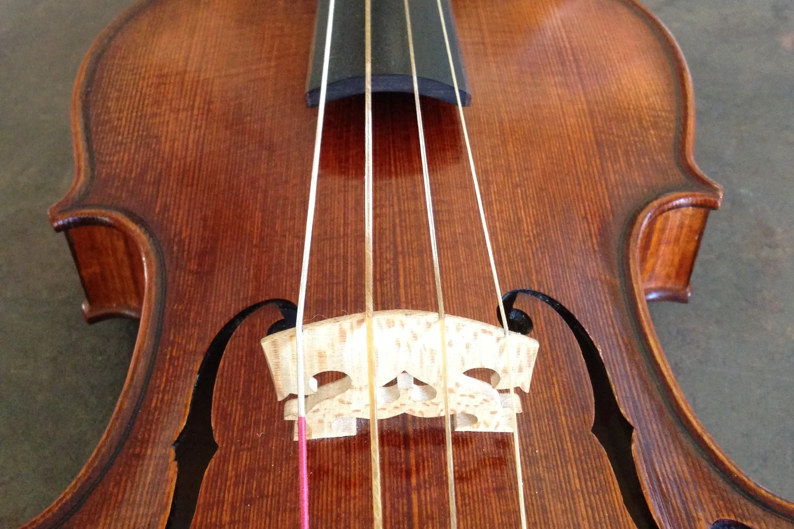 Violino barroco com cordas de tripa visto de cima, mostrando o cavalete e as aberturas em f