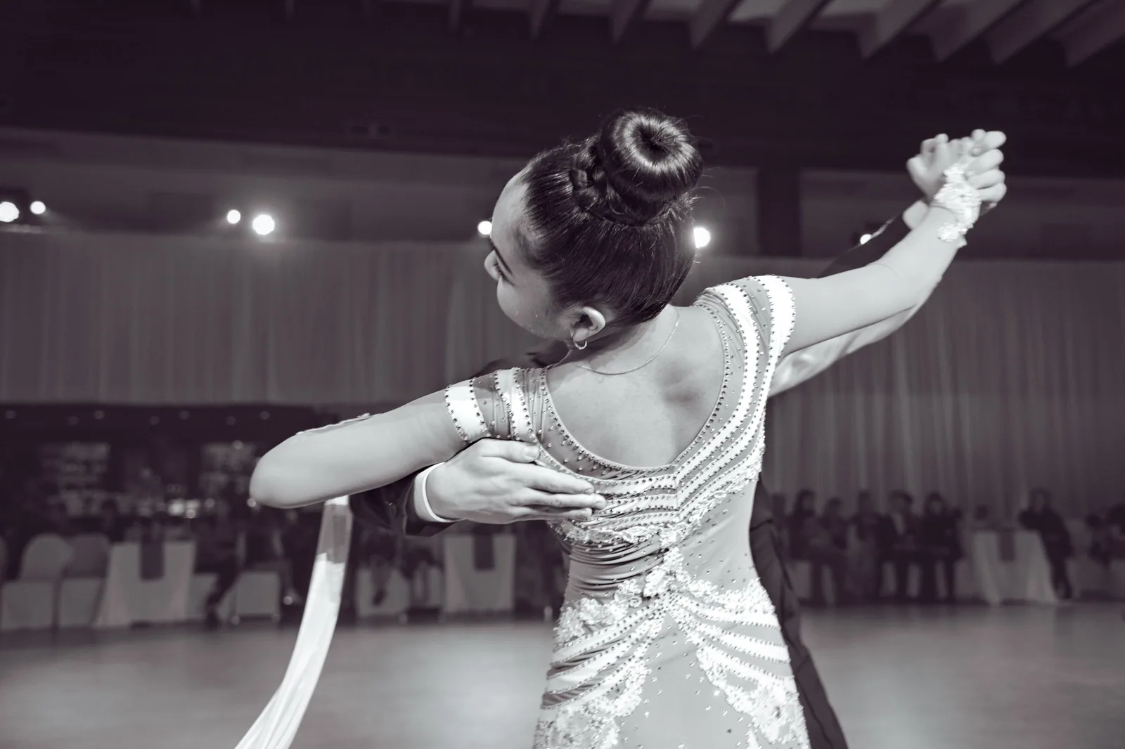 Dançarina de vestido bordado em passo de dança de salão