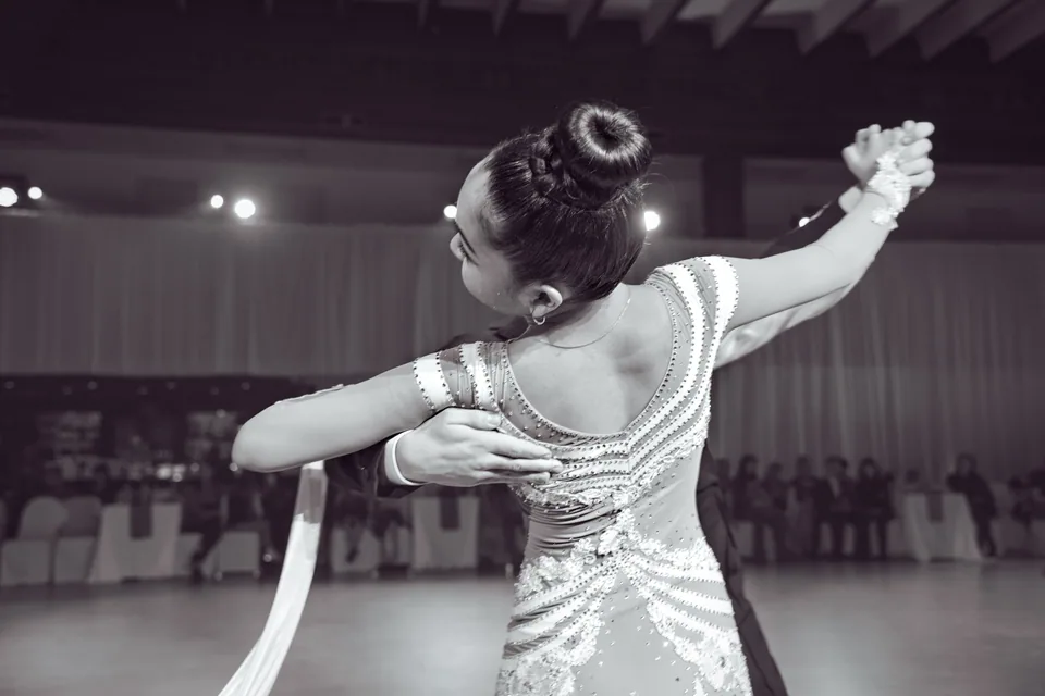 Dançarina de vestido bordado em passo de dança de salão