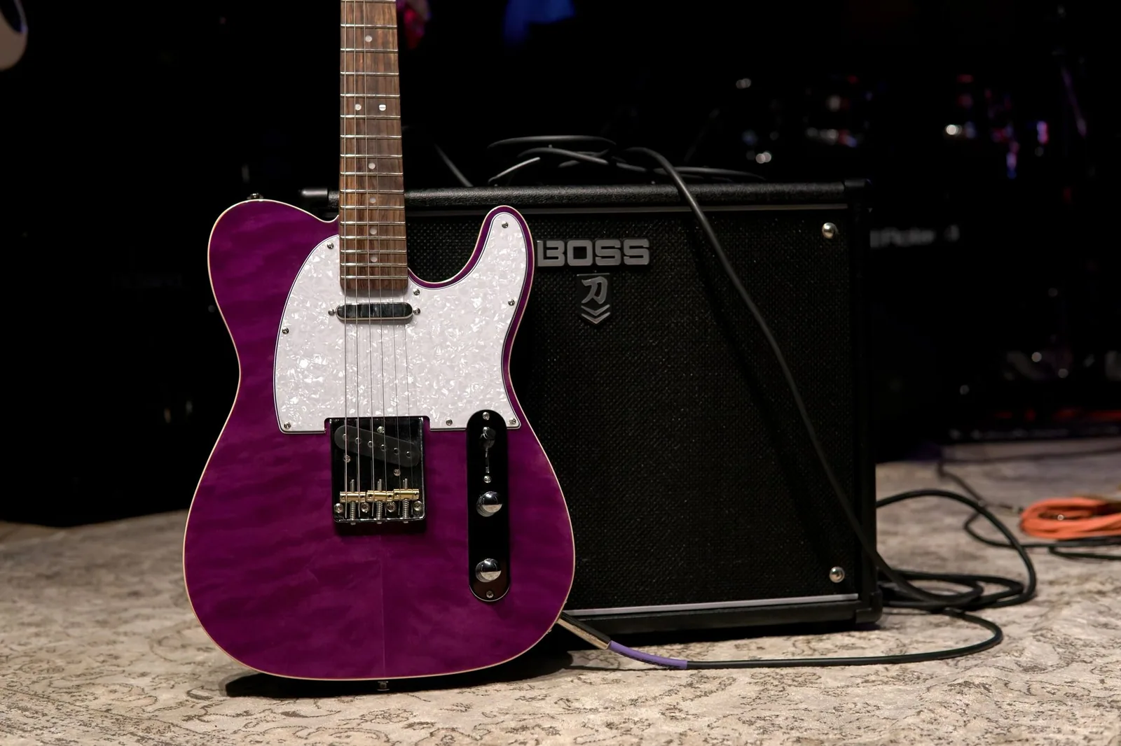 Guitarra elétrica roxa encostada em amplificador no palco (foto de banco de imagens)