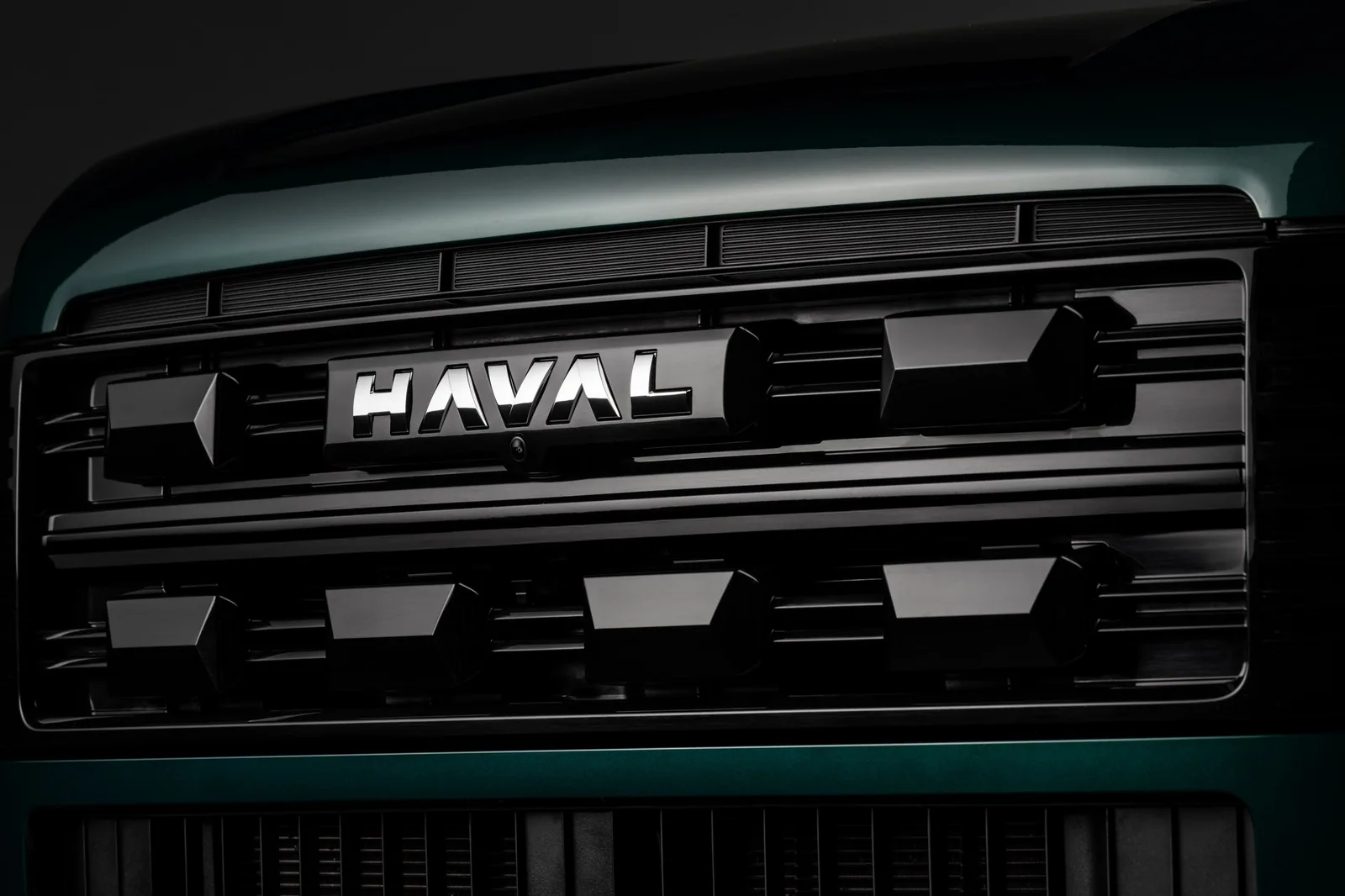 Detalhe da grade dianteira do SUV Haval H7 com o logo da marca iluminado