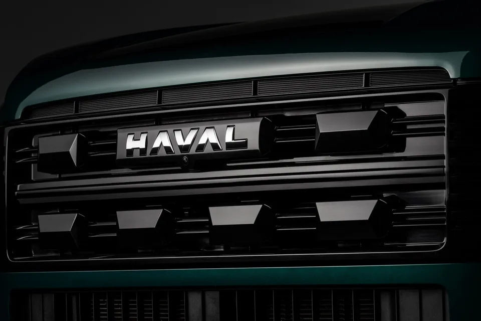 Detalhe da grade dianteira do SUV Haval H7 com o logo da marca iluminado