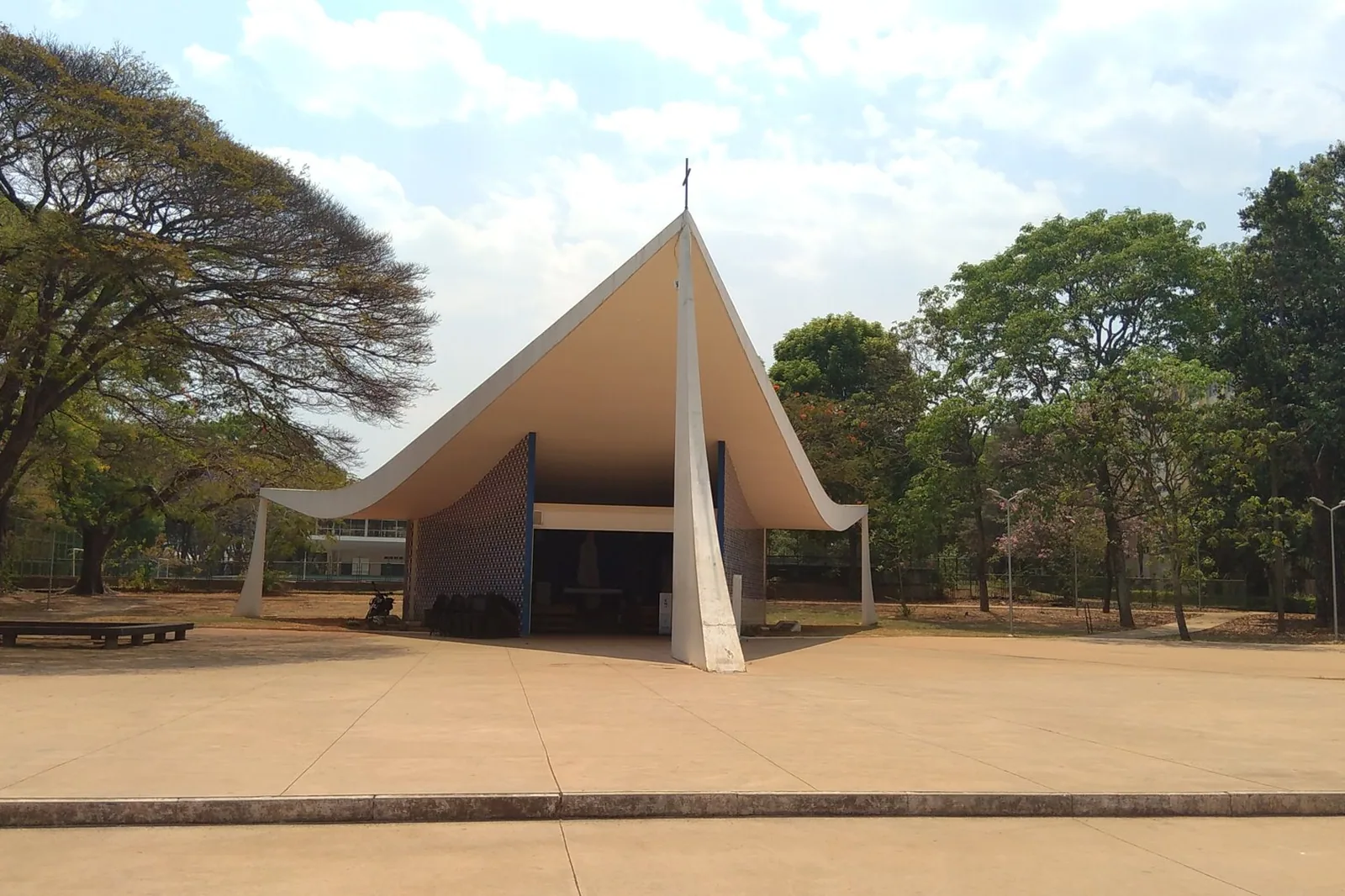 Igrejinha Nossa Senhora de Fátima, na Asa Sul, com a cobertura curva de concreto entre árvores