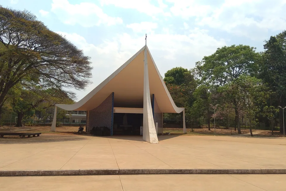 Igrejinha Nossa Senhora de Fátima, na Asa Sul, com a cobertura curva de concreto entre árvores