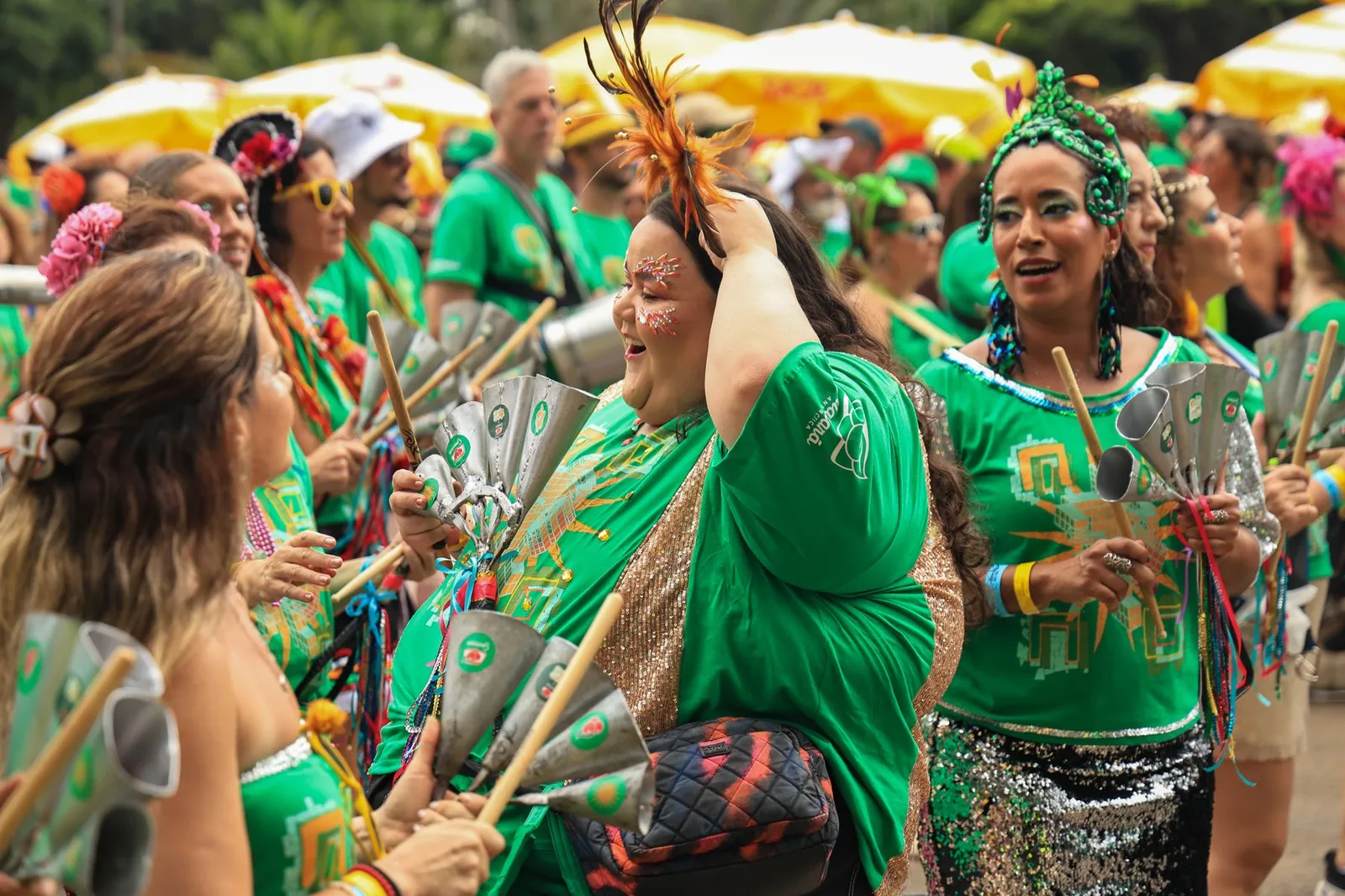 Foliões de verde tocam instrumentos de percussão em um bloco de carnaval de rua (foto ilustrativa de banco de imagens)