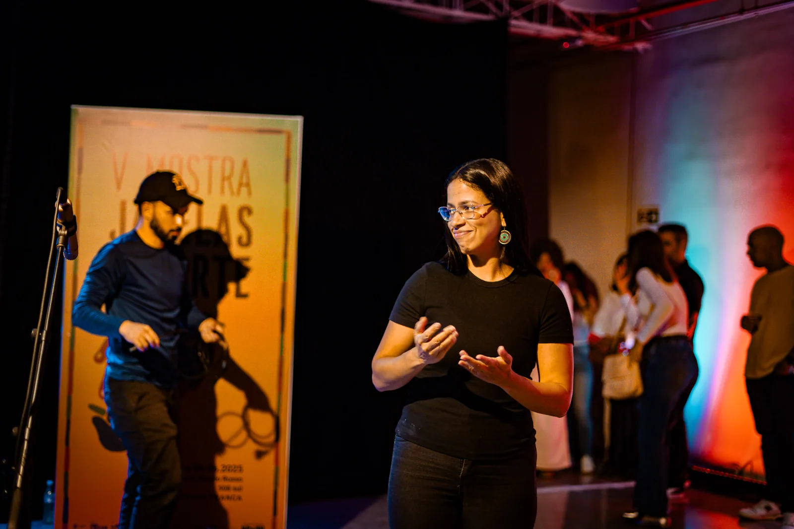 Intérprete faz Libras no palco durante evento do projeto Janelas da Inclusão