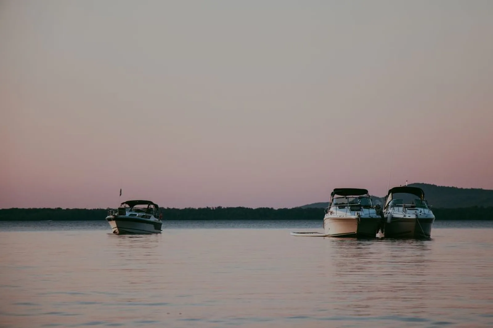 Barcos ancorados em lago tranquilo no fim da tarde
