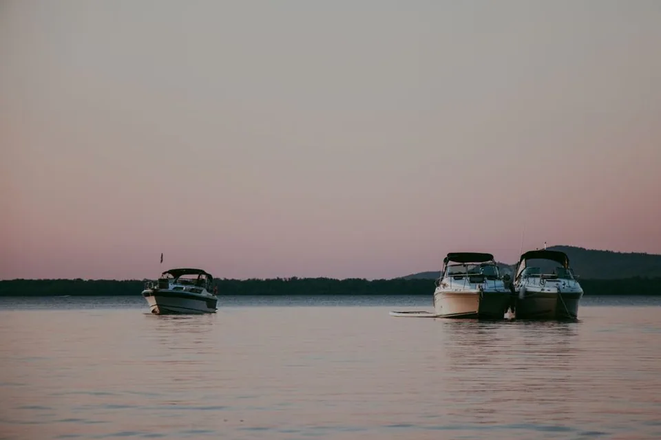 Barcos ancorados em lago tranquilo no fim da tarde