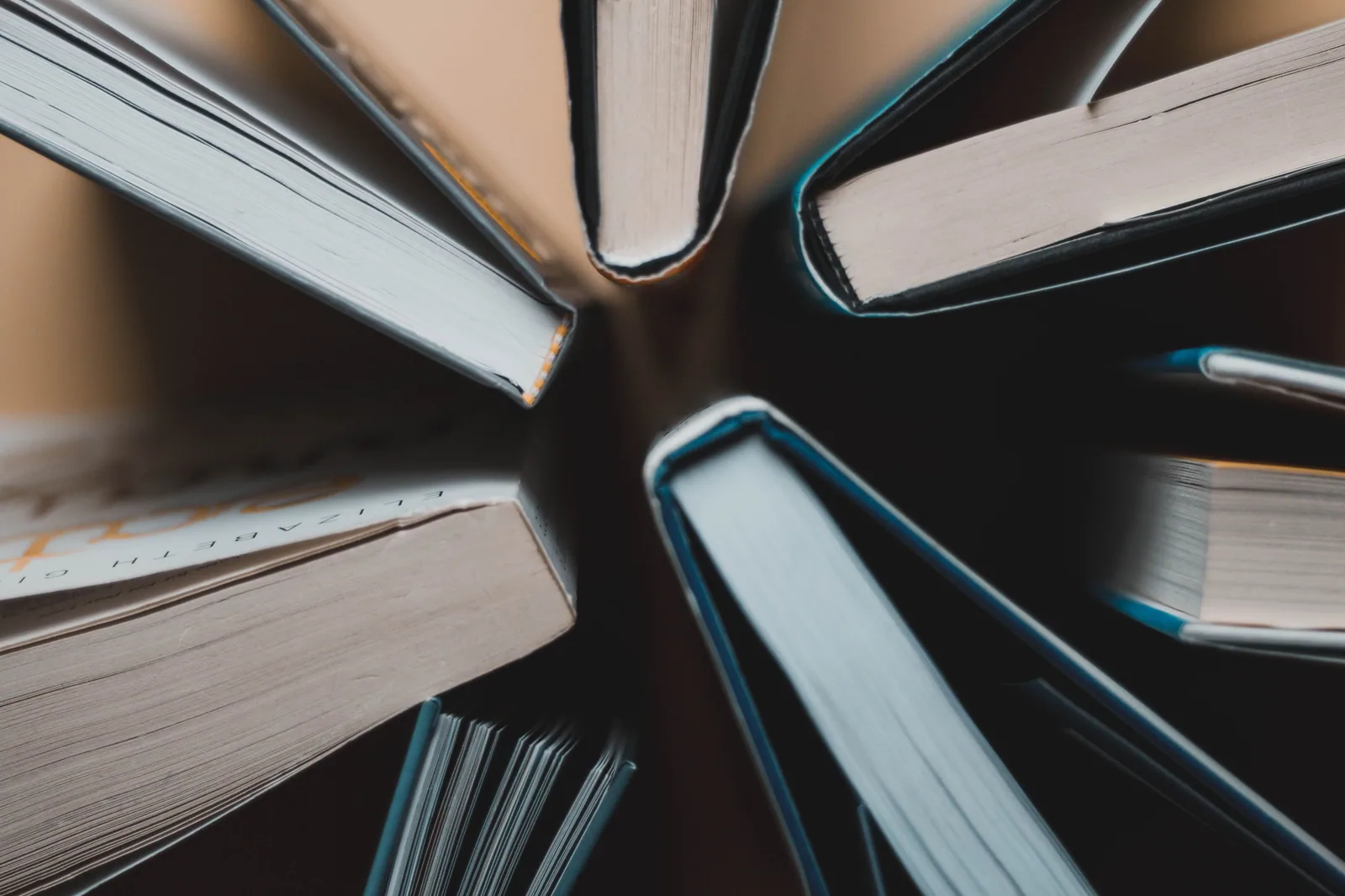 Livros de capa dura abertos e dispostos em círculo, vistos de cima