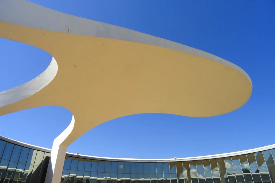 Cobertura em curva do Memorial dos Povos Indígenas, em Brasília, vista de baixo contra o céu azul