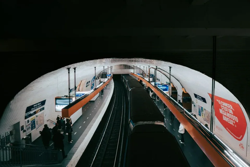 Plataforma de estação de metrô com trilhos e cobertura curva