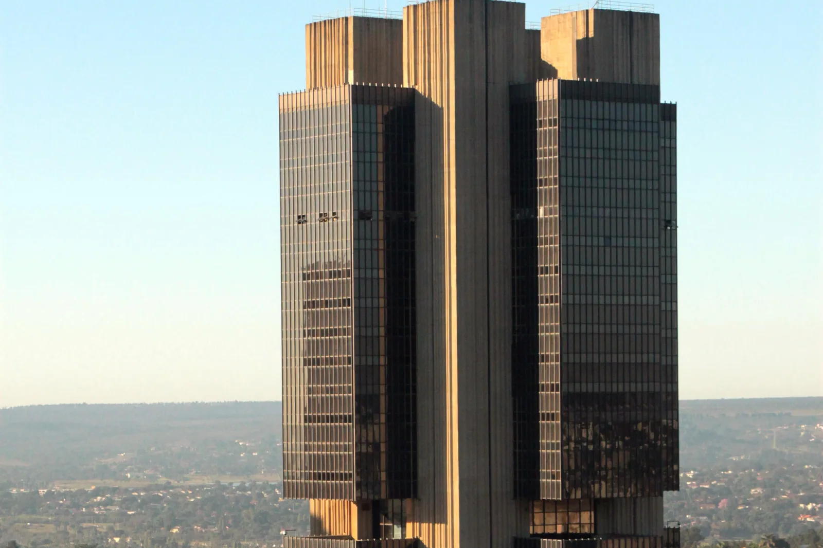 Fachada da torre do prédio-sede do Banco Central do Brasil em Brasília, vista de baixo para cima ao entardecer