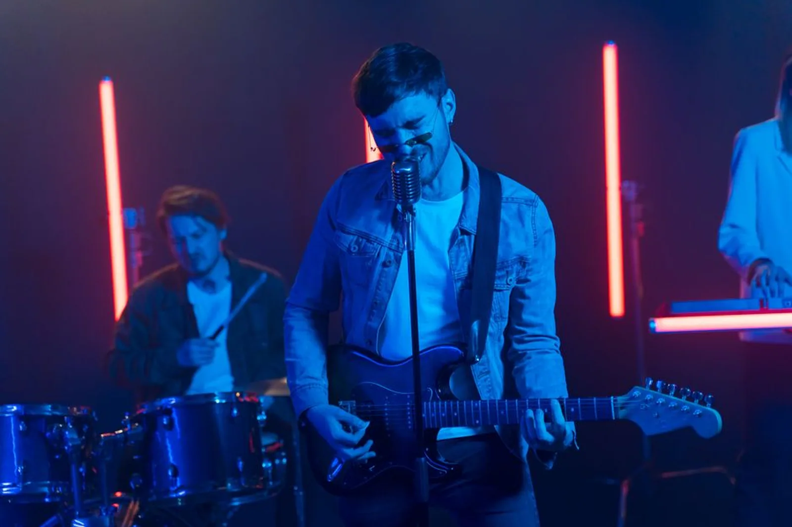 Banda tocando em casa de show com iluminação azul