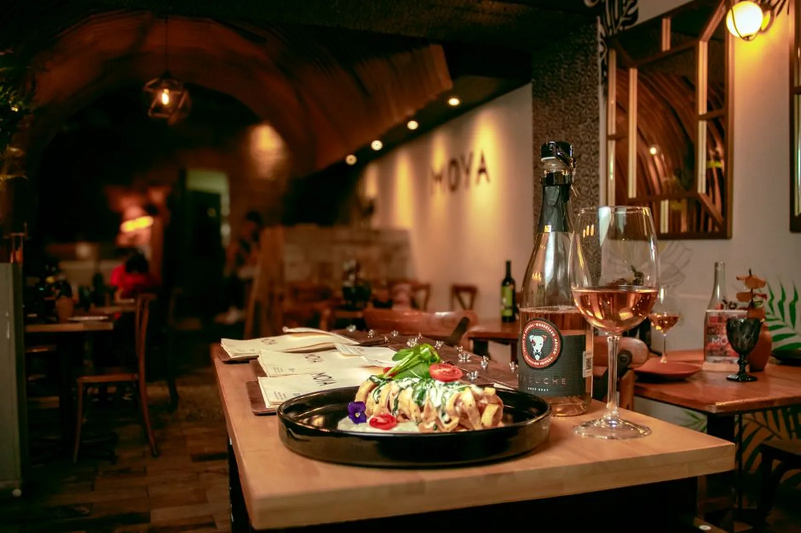 Salão de restaurante aconchegante com mesas postas e iluminação quente