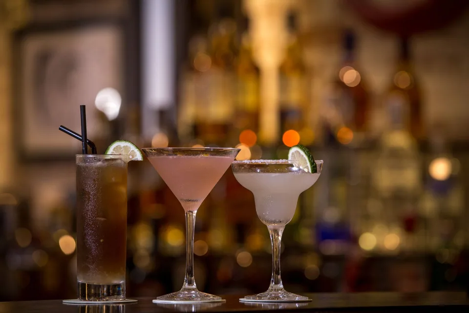 Três drinks no balcão de um bar, em imagem ilustrativa