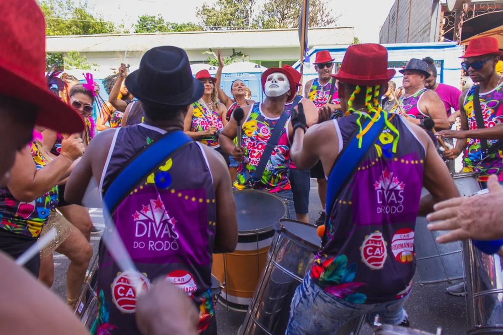 Bloco de percussão tocando na rua com público em volta