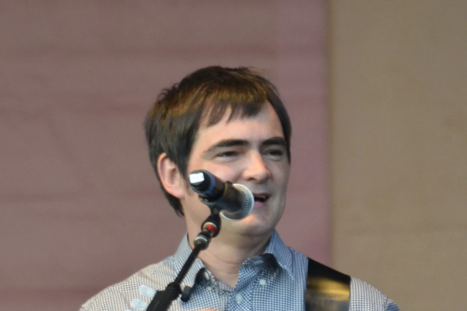Samuel Rosa cantando ao microfone com a guitarra a tiracolo, em foto de arquivo de 2014