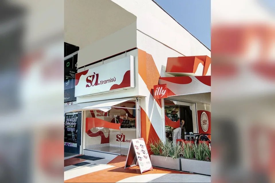 Fachada da Sù Tiramisù na 303 Sul, pintada de branco, vermelho e laranja, com placa da illy e cavalete com o cardápio na calçada