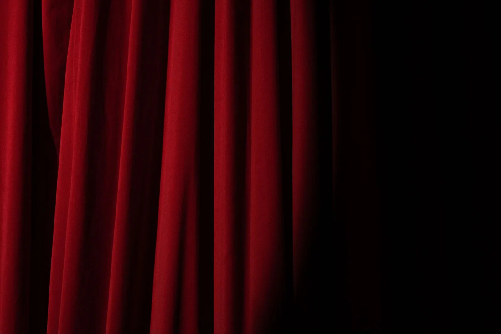 Detalhe de cortina de veludo vermelho de teatro com sombra à direita