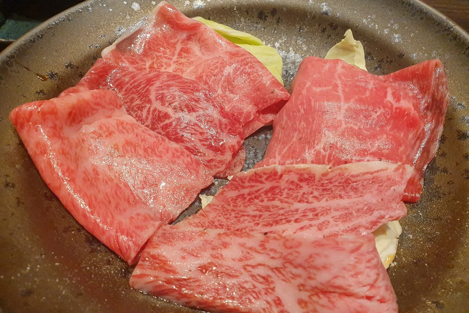 Fatias de carne bovina marmorizada em prato, prontas para grelhar no yakiniku