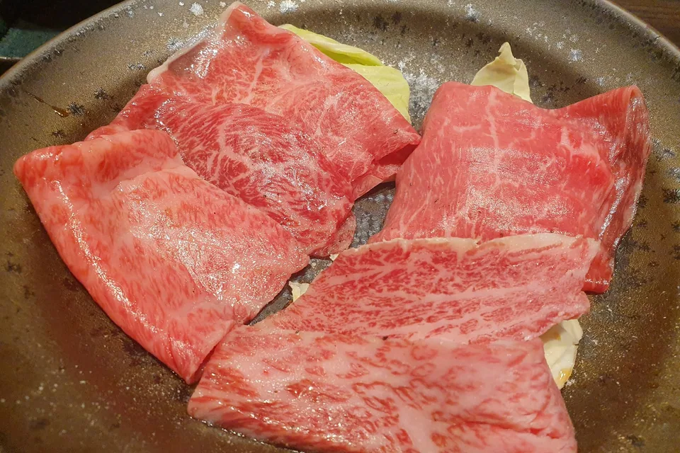 Fatias de carne bovina marmorizada em prato, prontas para grelhar no yakiniku
